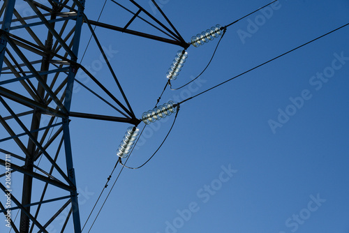 Canvas Print Sunlight catches the glass insulators on a transmission tower