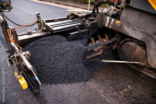 Asphalt Paver Machine Spreading Fresh Black Asphalt on a City Street