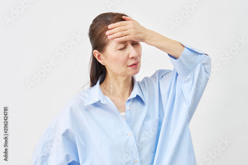 Foto 白背景で額に手を当てる女性