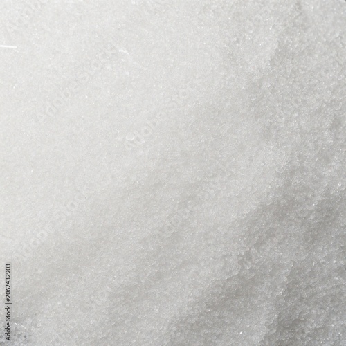 Granulated sugar texture background with fine sparkling crystals and soft white uneven surface