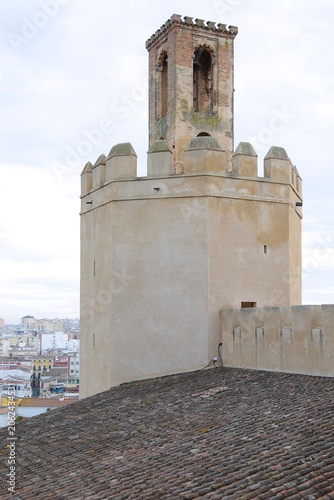 The historic Espantaperros Tower with its unique octagonal shape and brick belfry rising above the medieval fortification walls of the Alcazaba fortress in Badajoz, Extremadura, Spain.