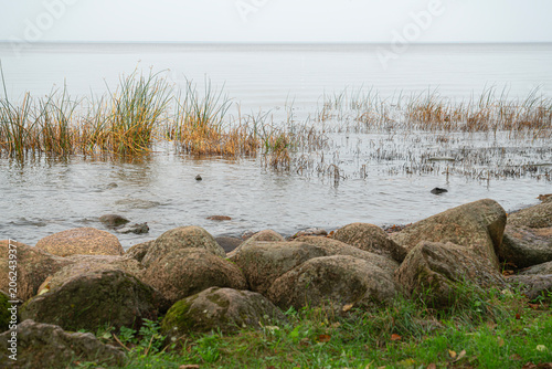 Rocks line the shore where water meets grass