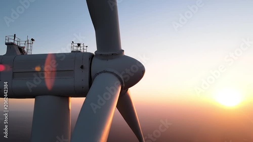 Close up of wind turbine rotating blades generating green energy at sunset
