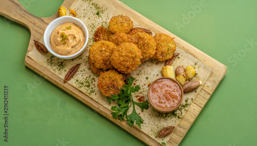 Crispy Golden Mandioca Frita with Spicy Pepper Sauce and Garlic on Green Background BBQ Braai Food Scene