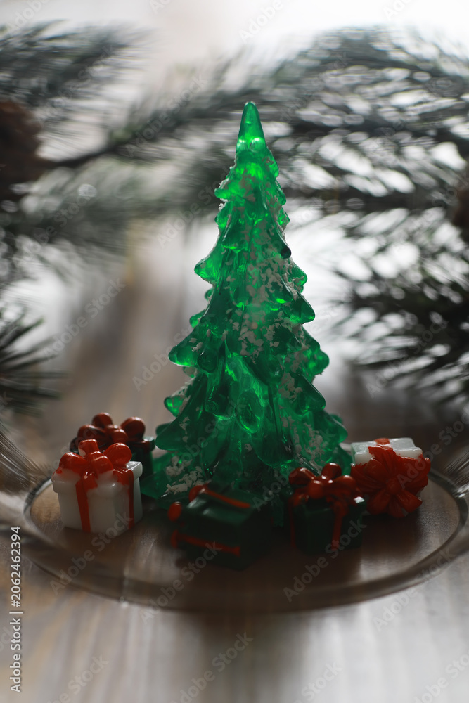 Fototapeta premium Festive Green Christmas Tree with Gifts and Pine Branches on Rustic Wooden Table