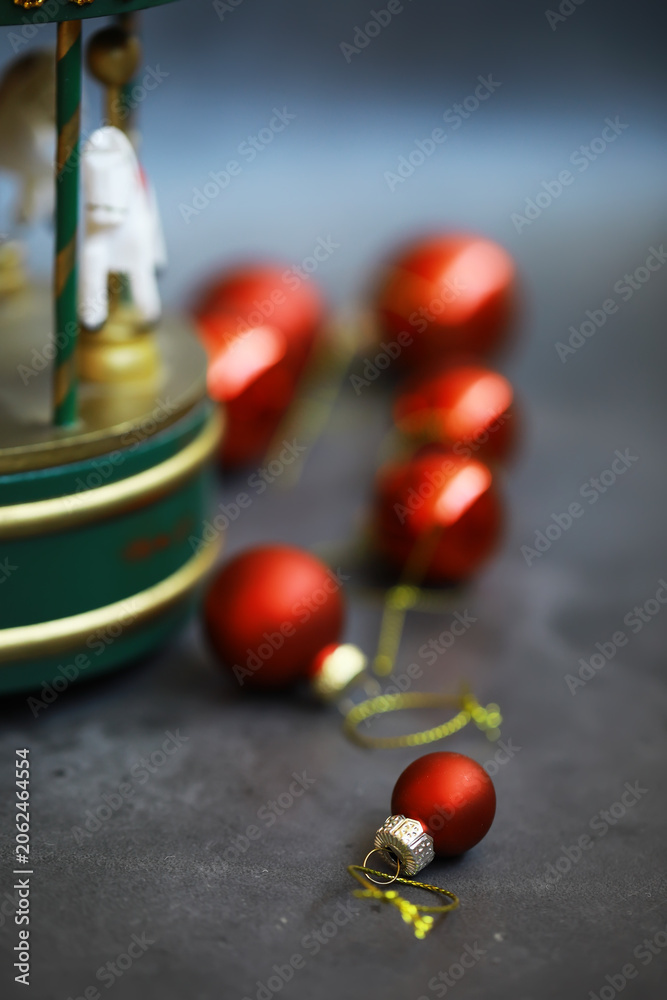Fototapeta premium Red Christmas Ornaments and Decorative Carousel: Festive Holiday Decor Close-Up