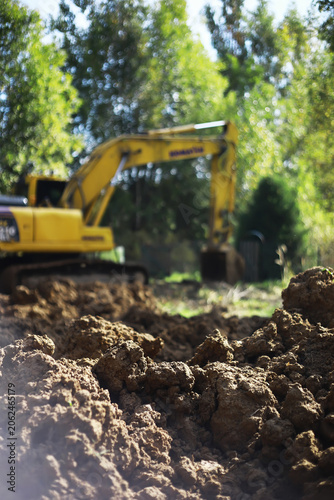 Excavator in Action: Construction Site Earthmoving Under Sunny Skies