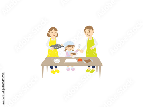 Foto 一緒にお菓子作りをする家族・女の子とエプロン姿の両親・チョコレートケーキ