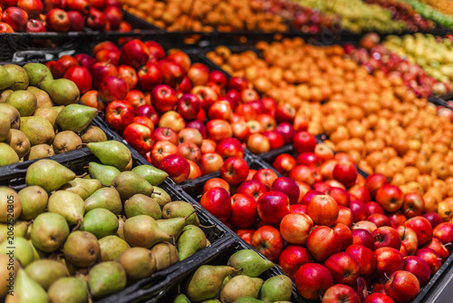 Colorful assortment of fresh apples and pears at supermarket produce department