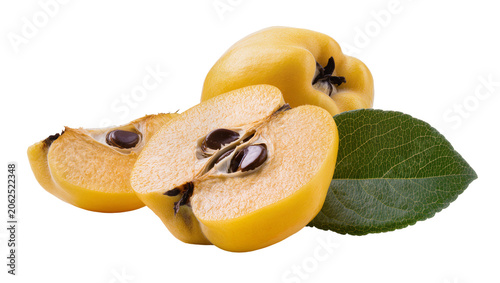 Whole and halved yellow quinces with seeds and green leaf