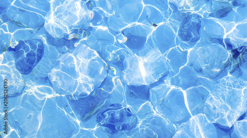 Clear light blue water ripples over smooth stones, creating serene and tranquil atmosphere