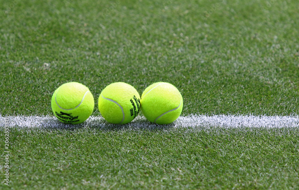 Naklejka premium Yellow tennis balls Slazenger Wimbledon 2026 on the green grass lawn of Rot Weiss Tennis Club in Berlin during the WTA 500 Berlin Tennis Open tournament