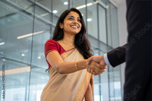 Indian Businesswoman Shaking Hands with Corporate Executive in Modern Office