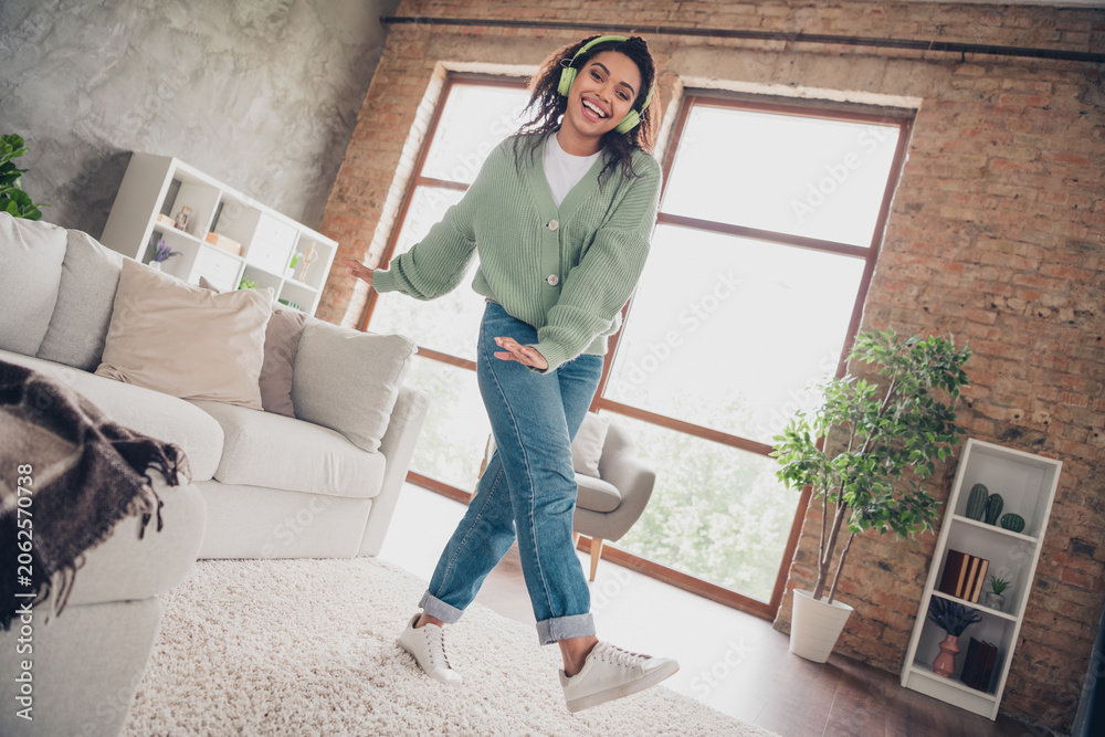 Fototapeta premium Full length photo of lovely young girl headphones dancing have fun dressed green knitted garment spacious house indoors room
