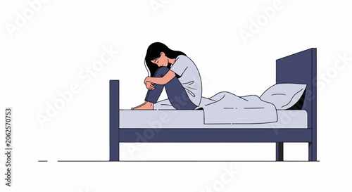 Woman curled up on a bed, head down, in a state of distress