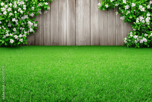 Wooden garden fence with green bushes and small white blooming flowers