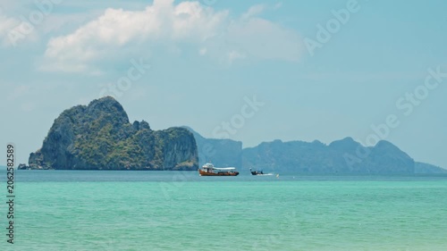 Boats cruising across turquoise ocean, tropical limestone karst islands and Andaman sea background, travel tourism and exotic summer vacation destination