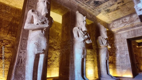 Interior view of the great temple of abu simbel with colossal statues of ramesses ii and ancient egyptian hieroglyphs on the walls and ceiling