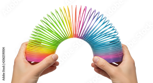 Hands stretching a colorful rainbow plastic spring toy in an arc shape