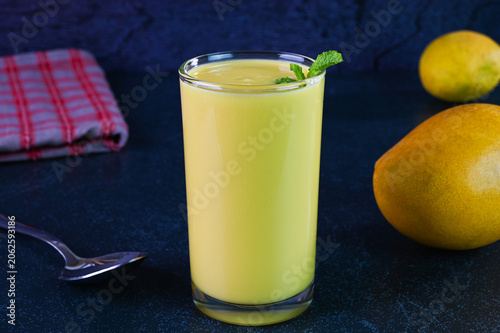 Mango lassi drink served in a glass cup.