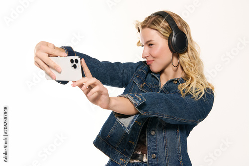 Foto Blonde woman expresses her style in denim while taking a cheerful selfie