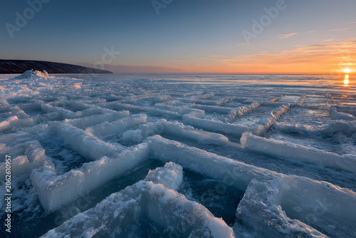 Golden light bathes a vast, intricate ice maze at sunset or sunrise, creating a stunning winter landscape with dramatic sky and reflective frozen surfaces.