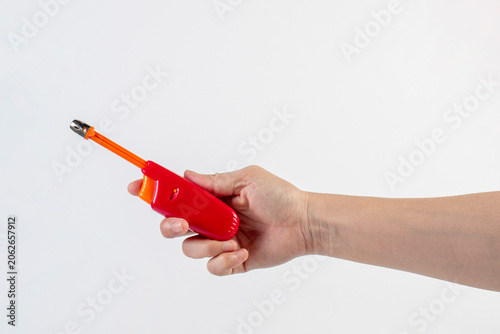 фотографія Red gas lighter gun for gas-stove and hand isolated on white background