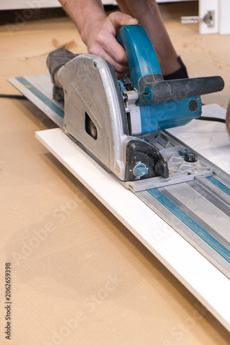 Hands using a circular saw to cut a board