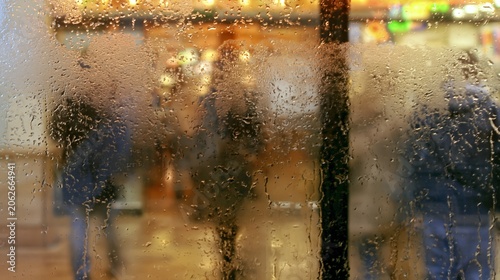 Rainy Day Reflections: A blurred, impressionistic view through a rain-streaked window, revealing silhouetted figures and warm, diffused lights.