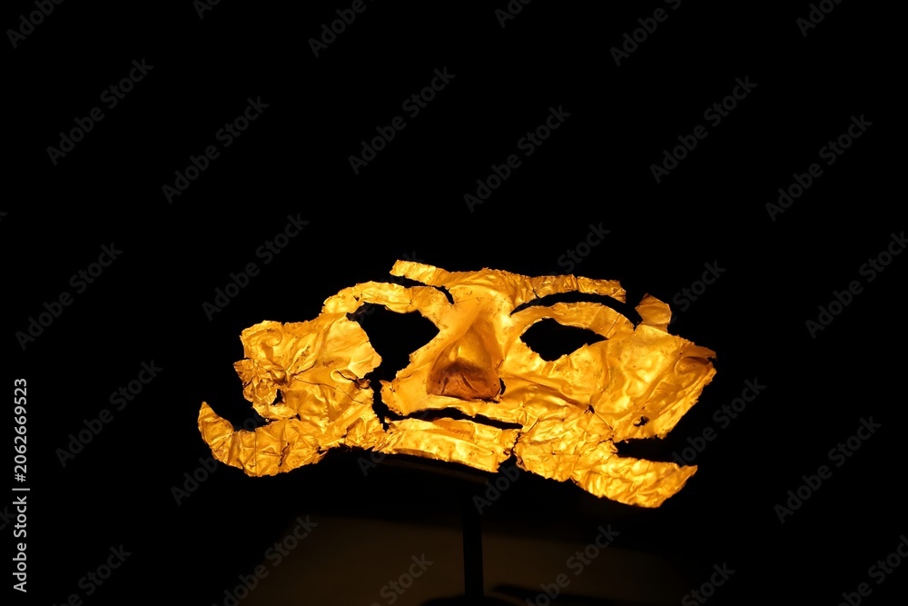 Obraz premium Ancient gold funerary mask on dark background