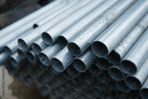 Stack of galvanized steel pipes arranged in rows at construction site storage area