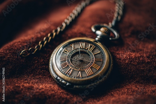 Antique pocket watch on maroon fabric