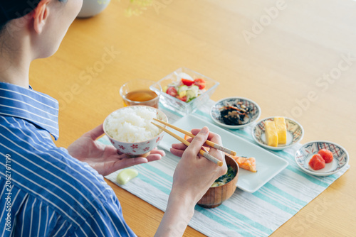 Bild auf Leinwand 家で朝ごはんを食べる若い女性の手元