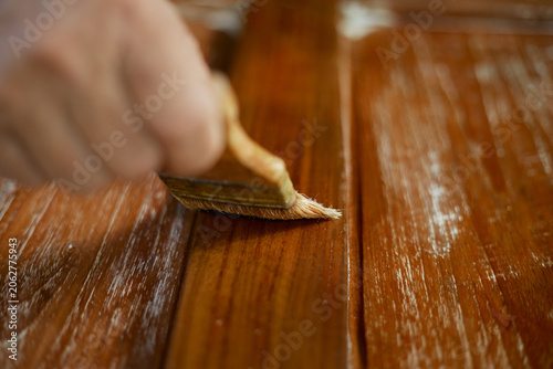 hand applying stain on wood