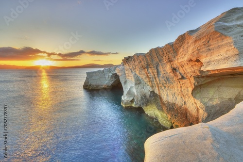 Morning light, sunrise, sun as star, orange-red sky, tuff rocks in morning sunlight, HDR, single grey clouds, Sarakiniko Beach, Milos Island, Cyclades, Greece