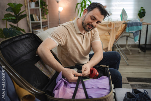 Man packing suitcase getting ready for business trip or vacation