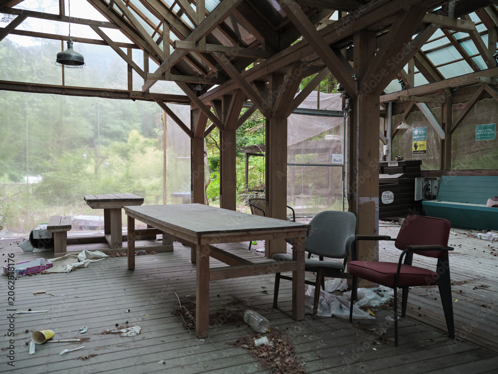 Fototapeta premium Abandoned Cafe Interior With Dusty Tables, Chairs, and Scattered Trash 