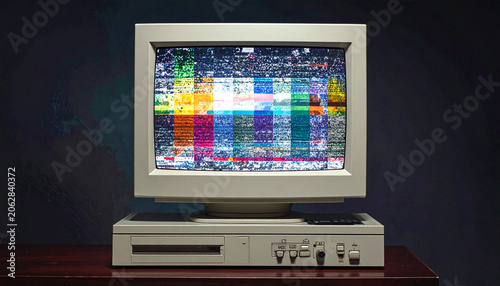 Retro computer monitor displaying colorful interference pattern against dark backdrop
