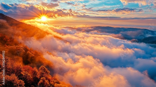 Golden sunrise illuminates a mountain slope covered in autumn trees above a sea of clouds