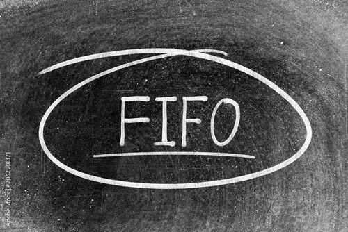 White chalk hand writing in word FIFO (Abbreviation of first in first out)  and circle shape on blackboard background