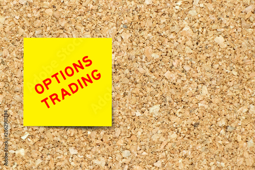Yellow note paper with word options trading on cork board background with copy space