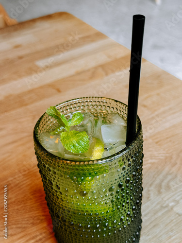 Refreshing mojito cocktail with fresh mint and lime on a wooden table