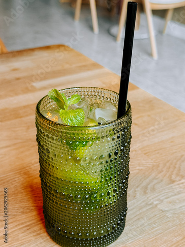 Refreshing mojito with mint and lime served in a textured green glass