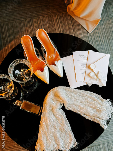 Elegant wedding day accessories laid out on a dark table for celebration