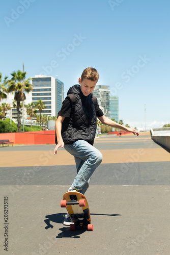 Handsome teenager standing with skateboard. Adolescent discovers city streets