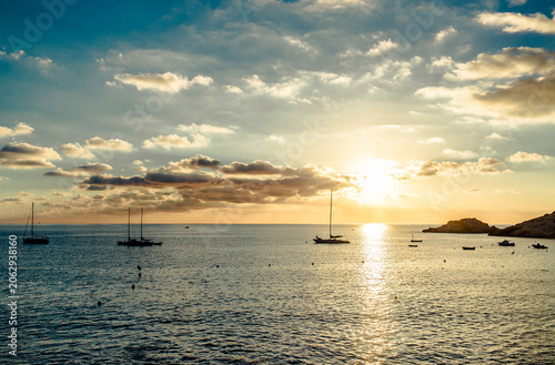 Magnificent sunset above the Mediterranean Sea and sailboats silhouette. Ibiza, Spain