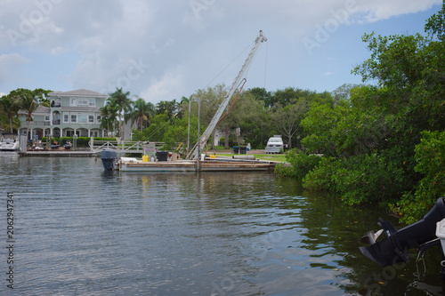Foto Work Boat Docked on Quiet Canal Near Mangroves Under Cloudy Sky With Reflections Crisp Park in St