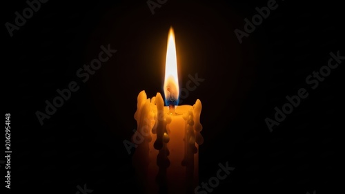 Single lit candle flame glowing with heavy melting wax.