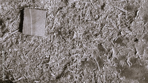Fotografie Monochrome overhead close-up of dense wood chips and sawdust with small plywood scrap, rough fibers, and construction material background