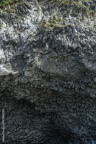 Fotografía Close-up view of a rugged rock formation with layered textures and moss-covered
